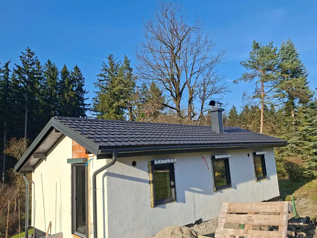 Pritlična novogradnja z dokončano temno kritino in dimnikom
