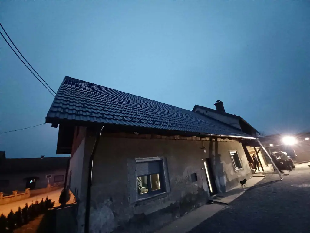 Streha z novo temno kritino v večerni svetlobi