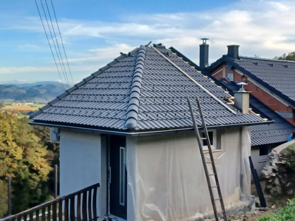 Strma šotorasta streha z novo temno kritino in slemenjaki